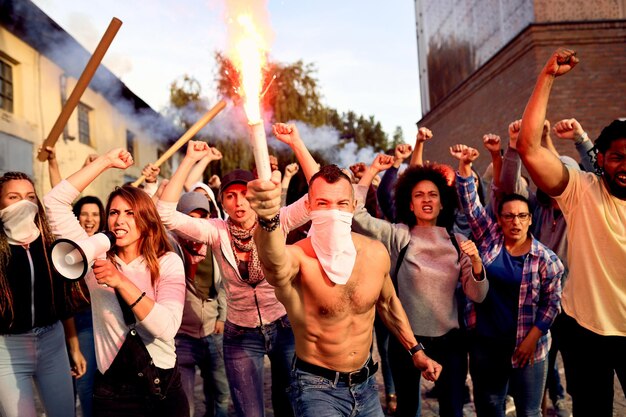 Разъяренная толпа людей, протестующих с зажженным факелом на улицах города