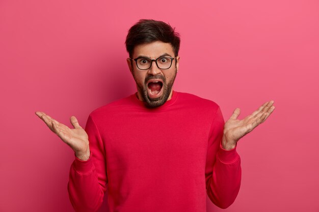 Furious enraged man looses temper, shouts angrily and bothered