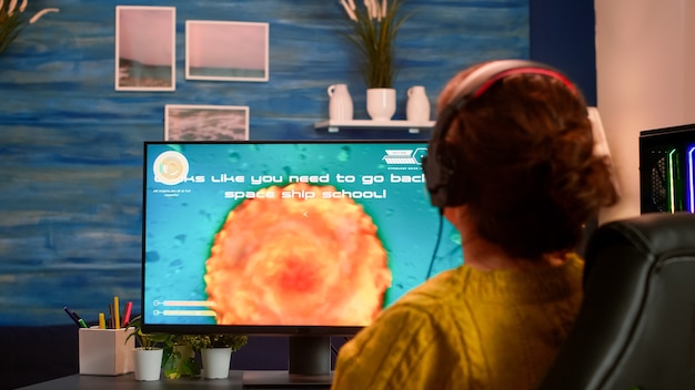 Разъяренный игрок проигрывает важное виртуальное соревнование по киберспорту в видеоигре космического шутера, играющей на мощном компьютере