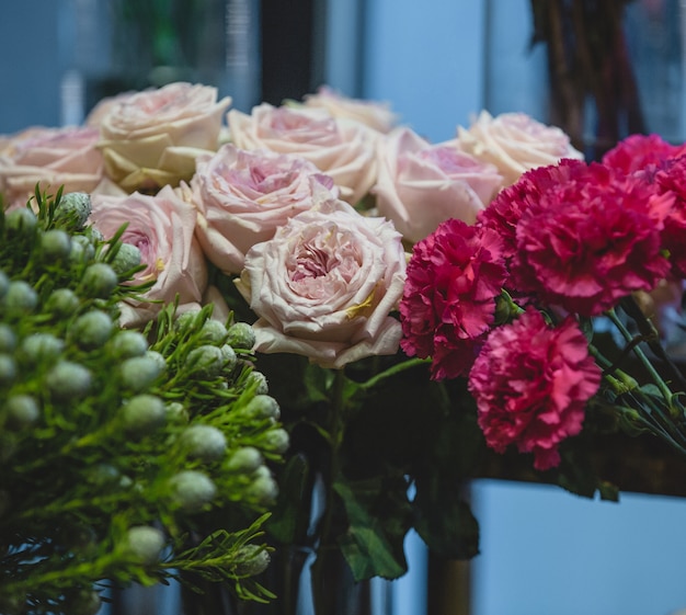 Fuscia carnations, pink roses and green blooms in one shot