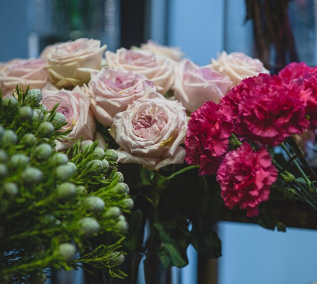 Fuscia гвоздики, розовые розы и зеленые цветы в одном кадре
