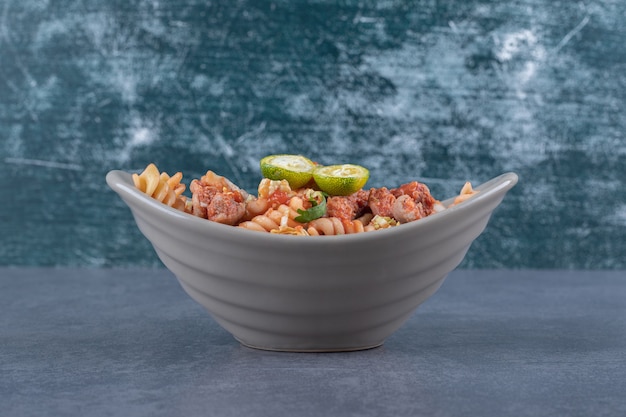 Fusilli pasta with chicken in ceramic bowl.