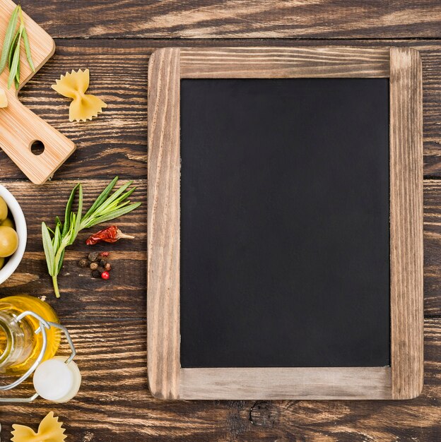 Fusilli with olives and vegetables beside chalkboard