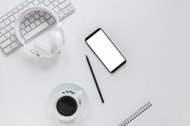 Gadgets near stationery and coffee cup