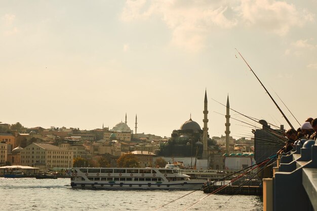 Galata Bridge with fishermen in Istanbul with a view of the city and ship