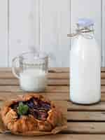 Free photo galette with plums and bottle with milk