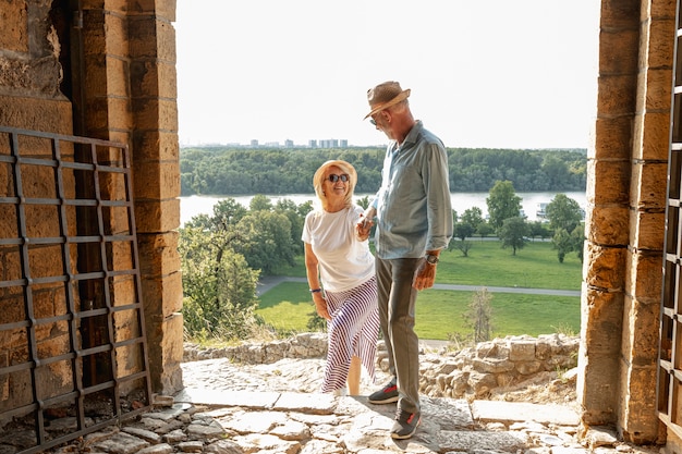 Free photo gallant man helping his woman to climb