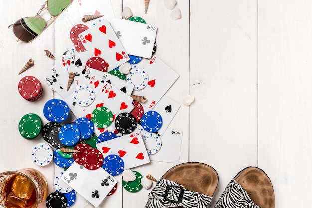 Free photo gambling. poker chips, cards and the dice nearby tablet on white wooden table. top view. copyspace. poker. summer. sun flare