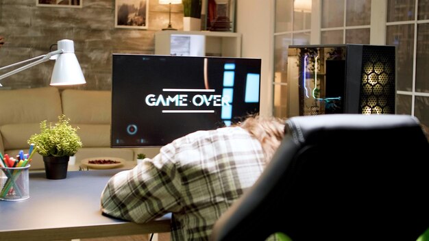 Game over for man with long hair while playing shooter games on powerful computer. Woman with vr headset.