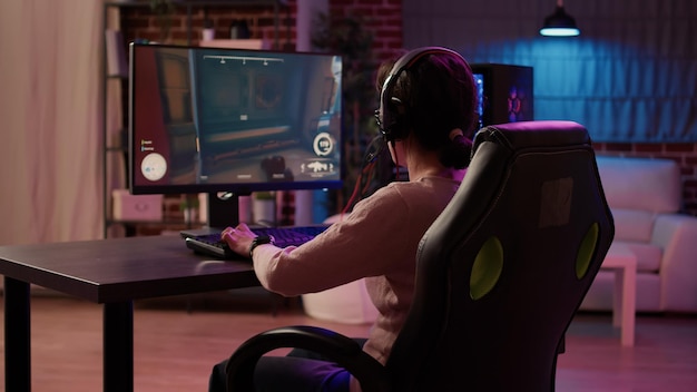 Free photo gamer girl using pc gaming setup relaxing playing multiplayer online action game talking using headset in tournament. woman streaming first person shooter while explaining gameplay to subscribers.