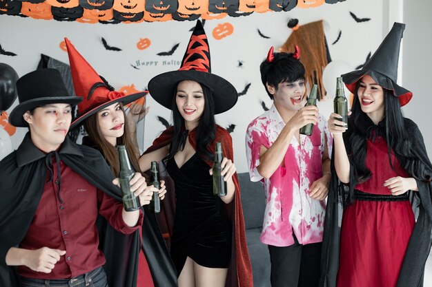 コスチューム魔女の若いアジア人をグループ化し、魔法使いはハロウィーンをテーマにした部屋でパーティーとセルフィーを祝います。笑顔でハロウィーン