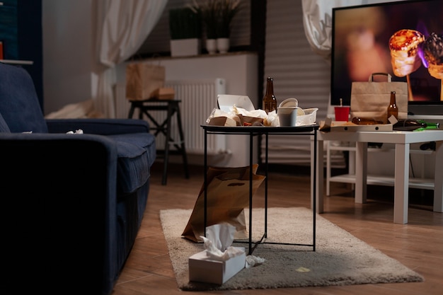 Free photo garbage table with empty beer drink bottle and food rubbish placed in living room