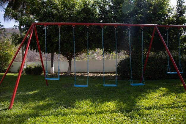 Free photo garden surrounded by greenery and blue and red swings under the sunlight in huatulco in mexico