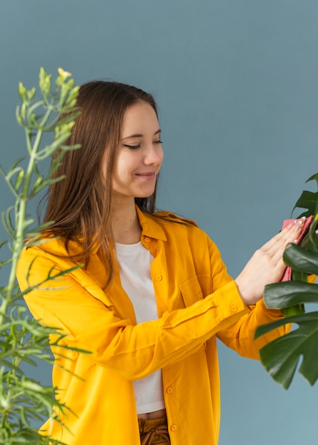 Free photo gardener cleaning the leaves of a plant