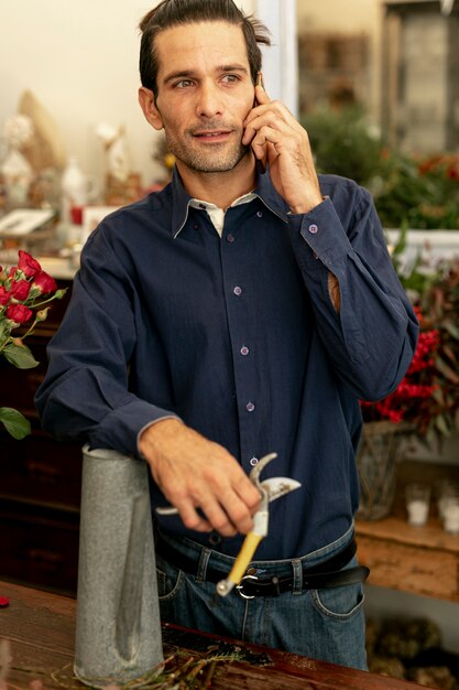 Gardener man with long hair talking on the phone