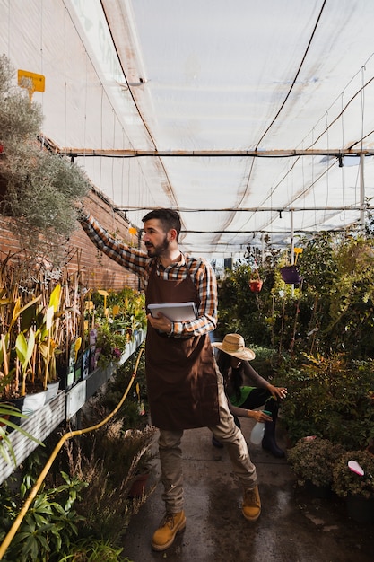 Free photo gardeners inspecting flowers