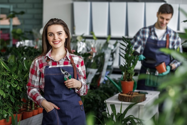 Gardeners with plants in beautiful garden center