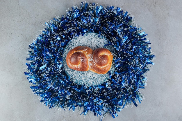 Free photo garland circle with a bun in the middle on marble