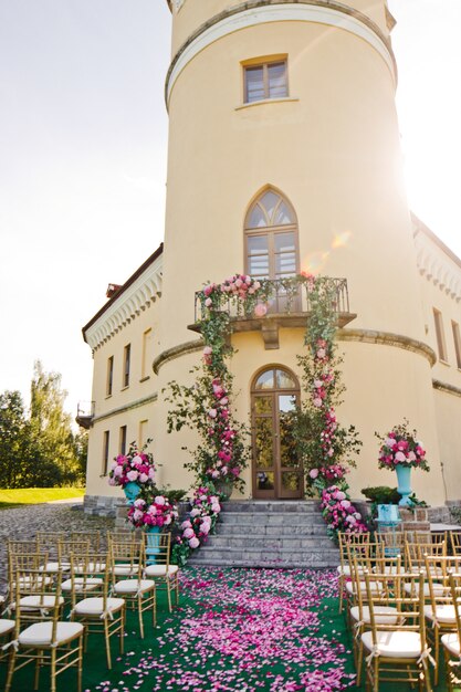 Garlands of greenery and pink flowers hang from the balcony over the stairs