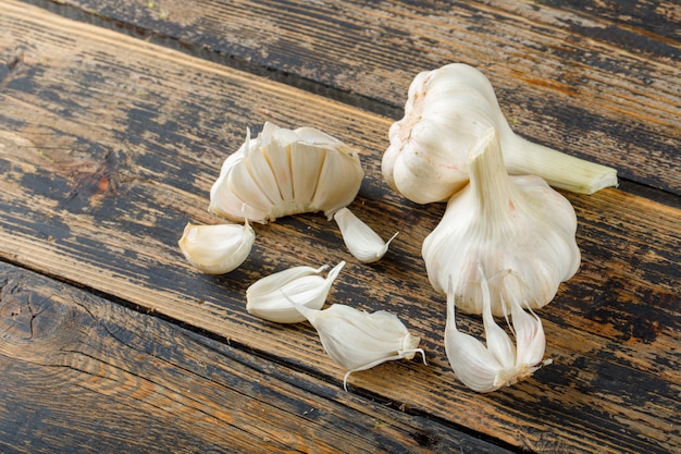 Garlic bulbs and cloves on a old wooden table. high angle view.