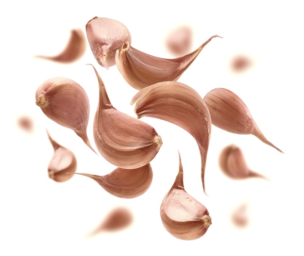Garlic cloves levitate on a white background