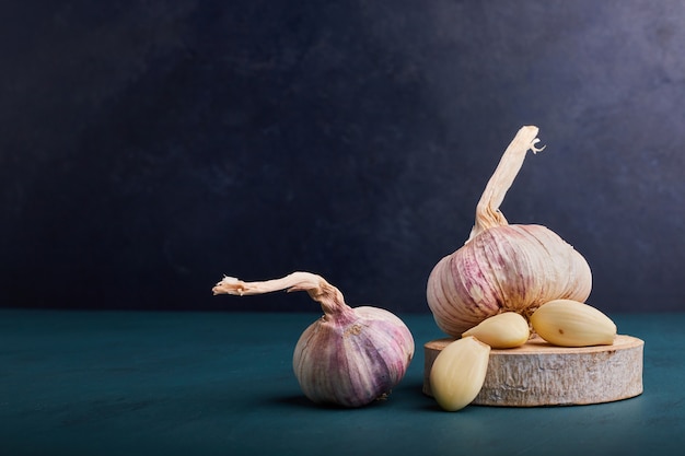 Garlic cloves on a piece of wood.