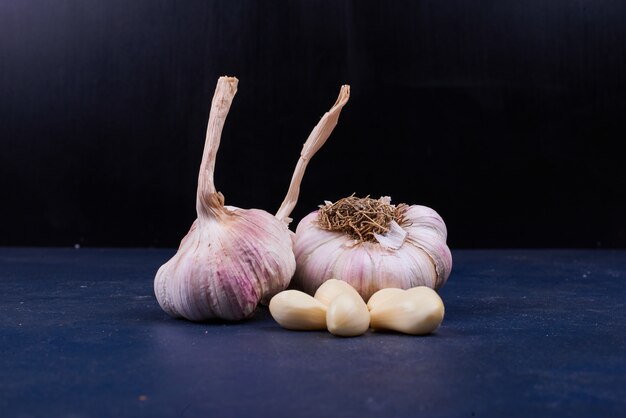 Garlic cloves whole and peeled on black.