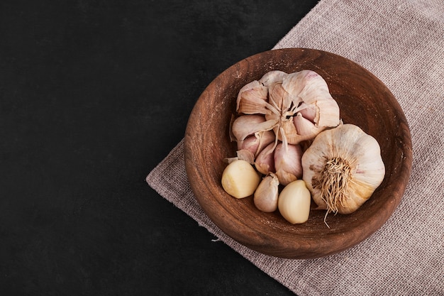 Garlic cloves in a wooden cup, top view. 