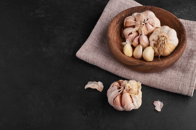 Garlic cloves in a wooden cup.