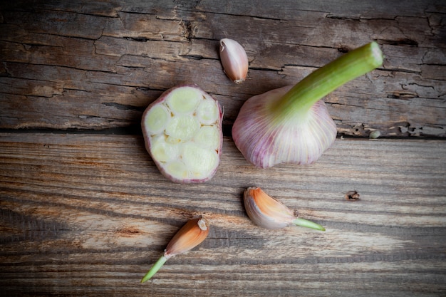 Garlic cut in a half on wooden background, top view.