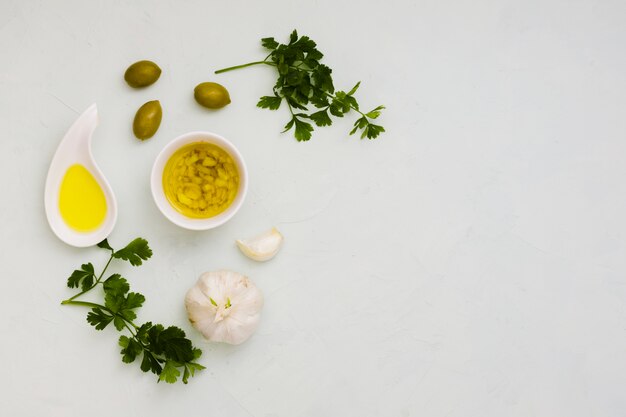 Garlic infused olive with olives and parsley leaves on white background