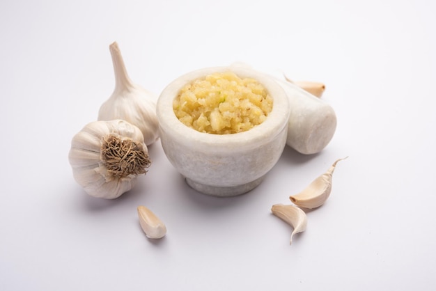 Garlic Paste or Lahsun Puree with raw whole, isolated over white background. Selective focus