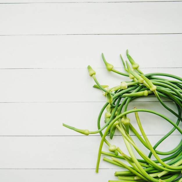 Garlic scape on white wooden table