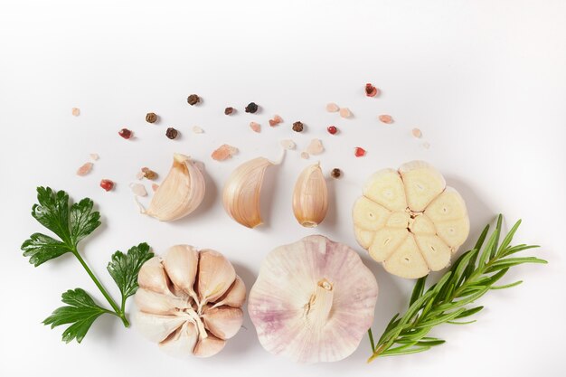 garlic with rosemary, parsley and peppercorn isolated on white surface. Top view. Flat lay . freshly picked from home growth organic garden. Food concept.