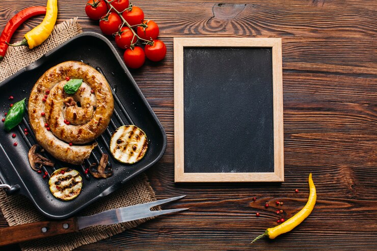 Бесплатный Фотография украсьте вкусные жареные спиральные колбаски возле чистого деревянного сланца на столе