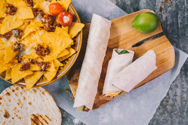 Garnished delicious mexican nachos in plate with tacos