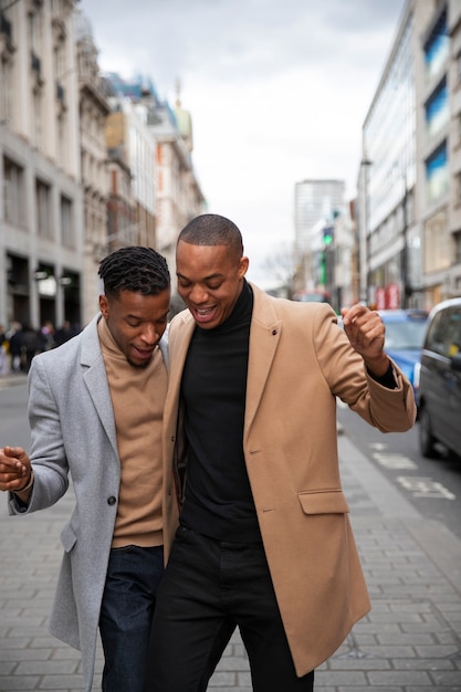 Gay couple being affectionate and acting goofy on a city street