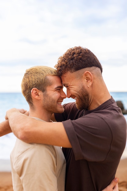 Free photo gay couple being affectionate and spending time together on the beach