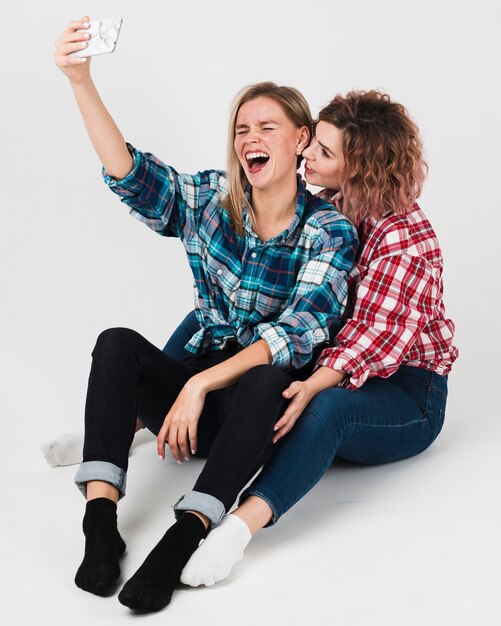 Gay couple laughing and taking selfie for valentines