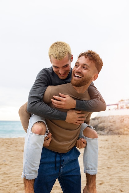 Free photo gay couple spending time together on the beach