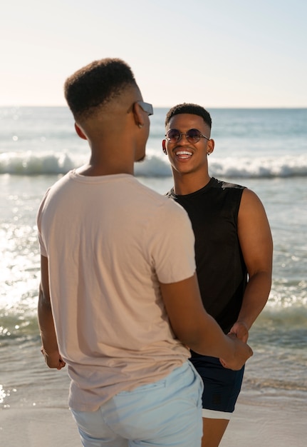 Foto gratuita coppia gay maschile sulla spiaggia