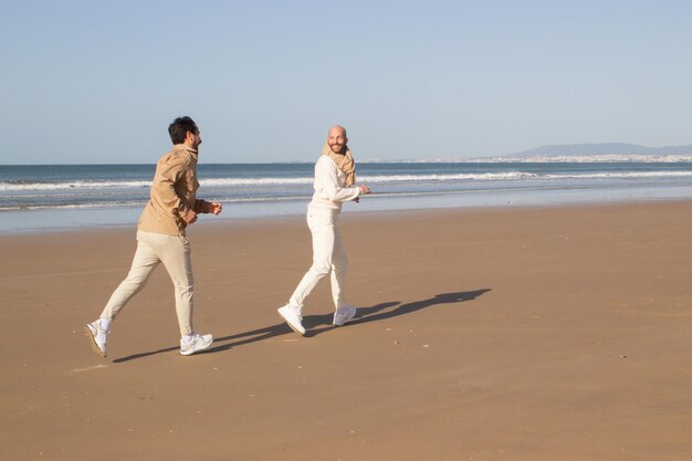 Gay man running after boyfriend on beach