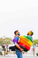 Free photo gay men in colorful powder having fun on festival