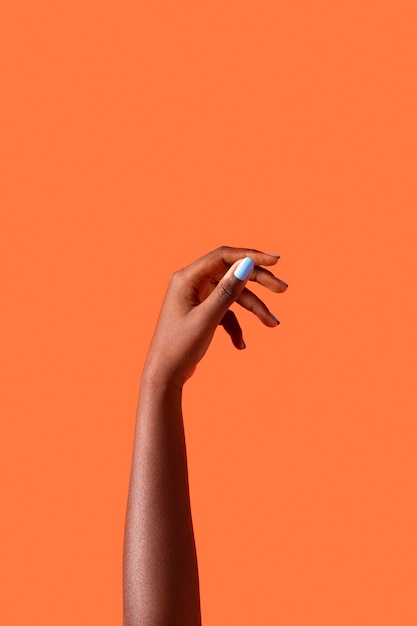 Gender fluid person hand isolated on orange