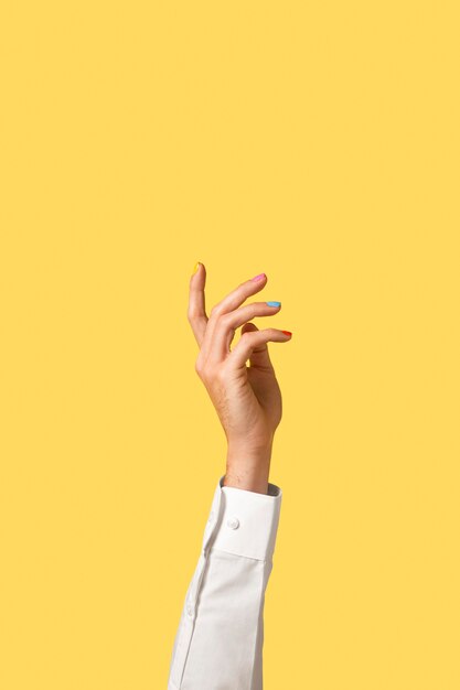 Gender fluid person hand isolated on yellow