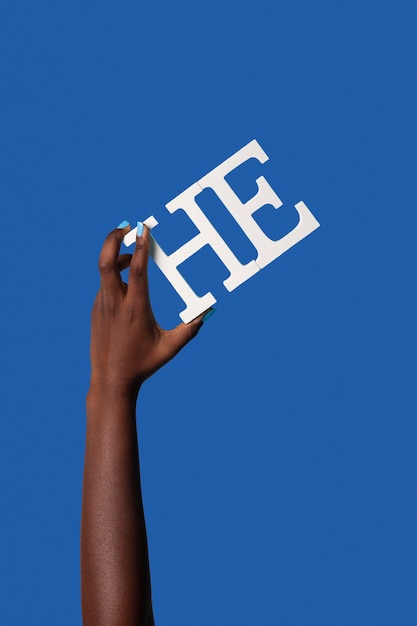 Gender fluid person holding a pronoun isolated on blue