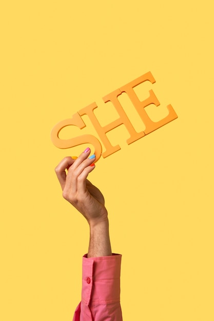 Free photo gender fluid person holding a pronoun isolated on yellow