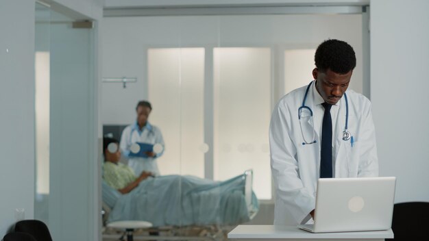 General practitioner looking at modern laptop to work on medical treatment and healthcare system. Physician using device to find checkup information to cure patient with disease.