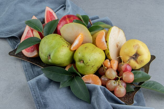 A generous serving of assorted fruits on a tray on marble 