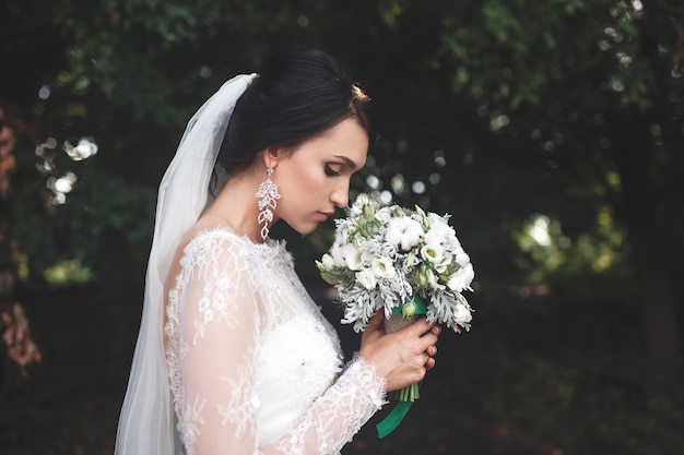 Gentle bride smelling bouquet